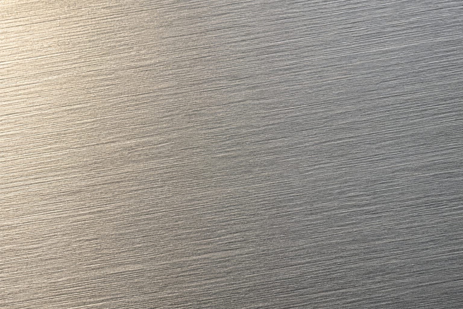 Extreme close-up of raw mill-finish aluminum surface showing fine parallel rolling striations